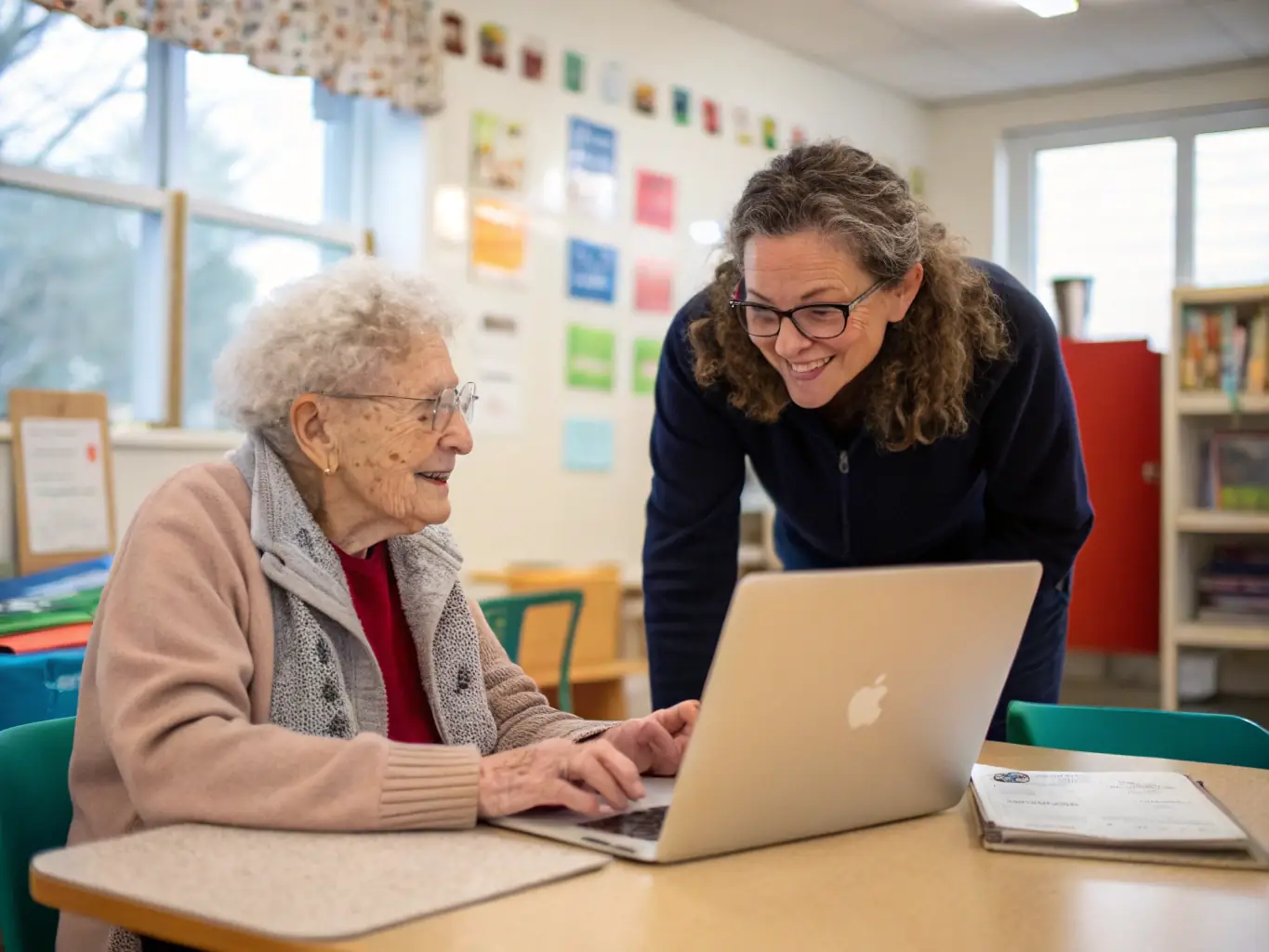 A photograph capturing a group of young volunteers assisting elderly individuals with using technology, such as tablets or smartphones, in a classroom setting.
